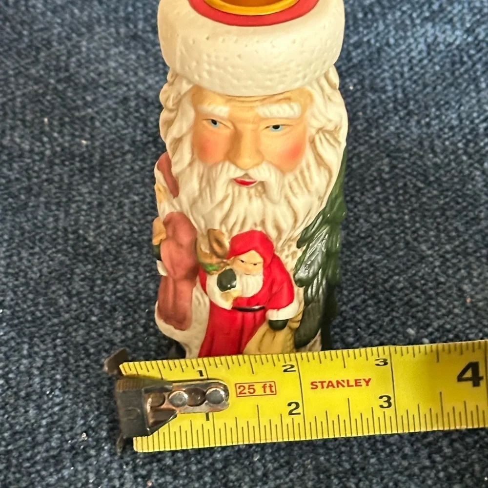Cute Santa ceramic candleholder. Multiple smaller Santas surrounding the holder.